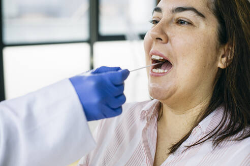Close-up of taking a swab from the patient's mouth - ABZF03020