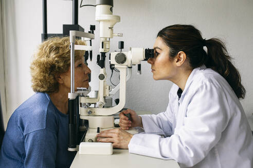Ophthalmologist examining eyesight of a senior patient - ABZF03022