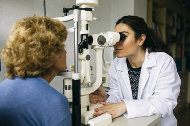 Augenarzt untersucht die Sehkraft eines älteren Patienten - ABZF03023