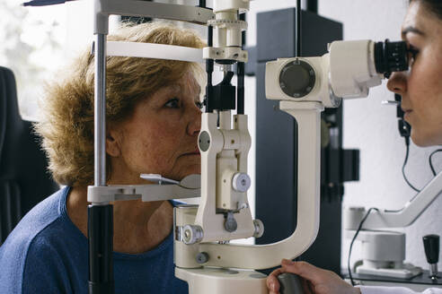 Augenarzt untersucht die Sehkraft eines älteren Patienten - ABZF03024