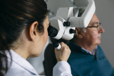 HNO-Arzt untersucht das Ohr eines älteren Mannes - ABZF03027