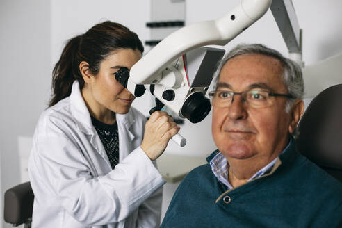 ENT physician examining ear of a senior man - ABZF03028