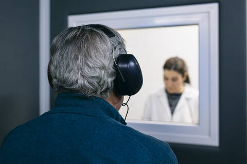 Doctor giving instructions to patient during a hearing test stock photo