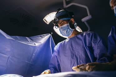 Operating room nurse and surgeon during an operation - ABZF03054