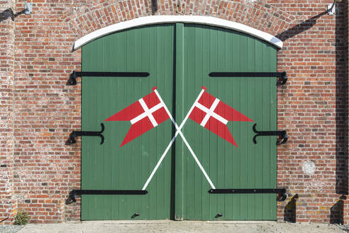 Dänemark, Romo, Dänische Flaggen auf Holztor der Feuerwache gemalt - ASCF01136