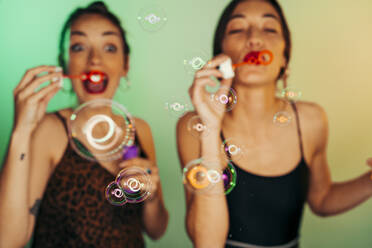 Two friends blowing soap bubbles - MPPF00691