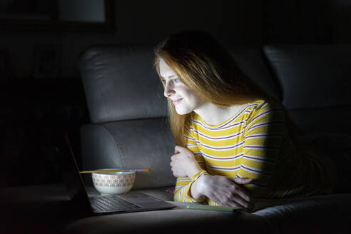 Young woman having a laptop video conference on the couch at home - AFVF05781