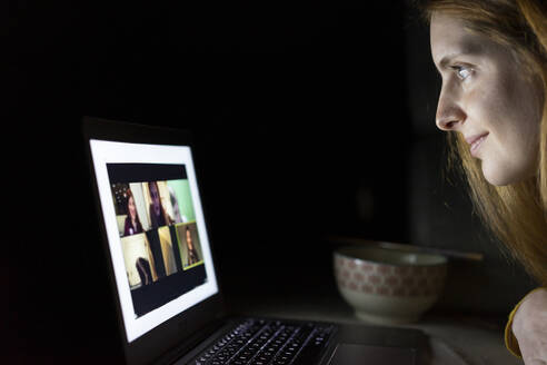 Young woman having a laptop video conference on the couch at home - AFVF05789