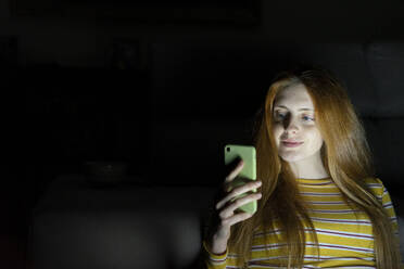 Young woman using smartphone in the dark - AFVF05793