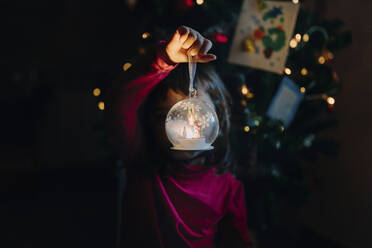 Kleines Mädchen hält beleuchtete Glaskugel zur Weihnachtszeit - GEMF03502