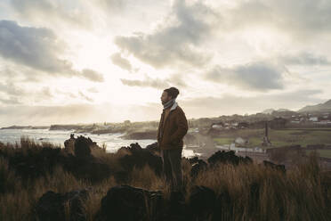 Man standing in wild landscape at the coast, Sao Miguel Island, Azores, Portugal - AFVF05809