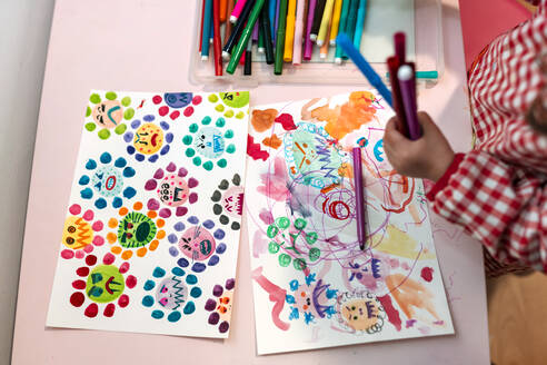 Little girl drawing ugly viruses with color markers at home - GEMF03507
