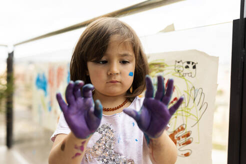 Kleines Mädchen, das mit ihren bemalten Händen herumspielt - VABF02671