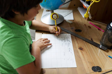 Boy doing his homework, sitting at desk - VABF02675