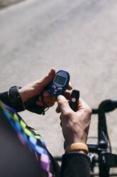 Close-up of diabetic cyclist checking his sugar level - ABZF03063