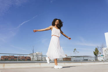 Portrait of happy young woman dancing - TCEF00324