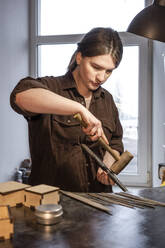 Goldschmiedin bei der Arbeit an einem Ring in ihrer Werkstatt - VPIF02153