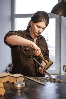 Female goldsmith working on ring in her workshop - VPIF02153