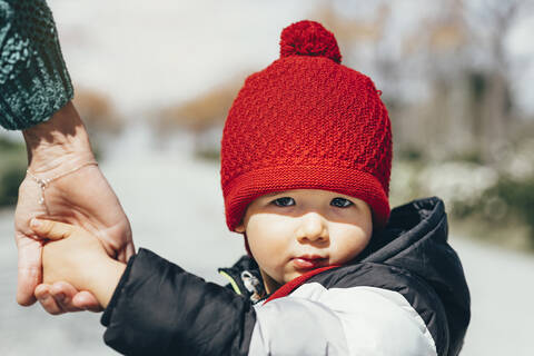 Porträt eines kleinen Jungen mit roter Pudelmütze, lizenzfreies Stockfoto