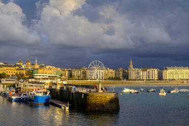 Spain, Gipuzkoa, San Sebastian, Storm clouds over harbor of coastal town - LBF02965