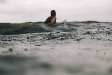 Männlicher Surfer während der Regenzeit, Sumbawa, Indonesien - KNTF04514