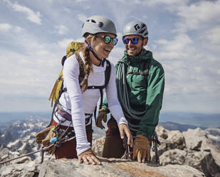 Ein Paar lächelt vor Freude, nachdem es den Gipfel des Grand Teton in Wyoming erreicht hat - CAVF77627