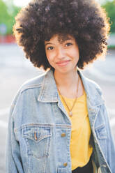 Porträt einer jungen Frau mit Afrofrisur in der Stadt - MEUF00240
