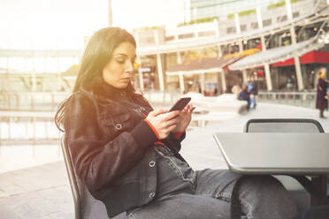 Beautiful woman using smartphone in a cafe - MEUF00286