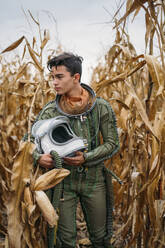 Junger Raumfahrer geht durch ein Maisfeld - JCMF00447