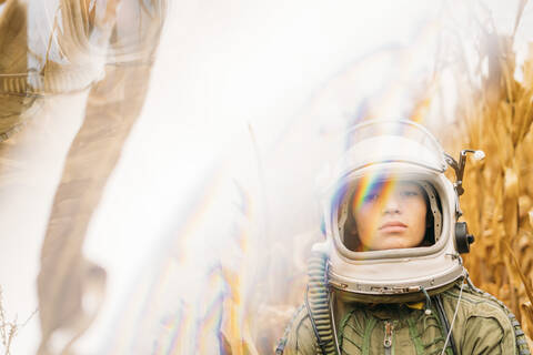 Young spaceman standing in wilted corn field stock photo