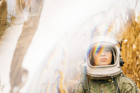Junger Raumfahrer in einem verwelkten Maisfeld stehend - JCMF00453