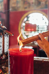 Malaysia, Hand of woman burning incense inside temple - JCMF00478