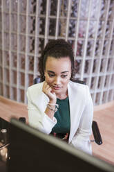 Porträt einer jungen Geschäftsfrau bei der Arbeit am Schreibtisch im Büro - LJF01437
