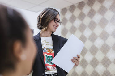Porträt einer jungen Geschäftsfrau mit Papieren im Büro - LJF01463