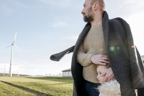 Vater und kleine Tochter auf einem Feld im Winter, lizenzfreies Stockfoto