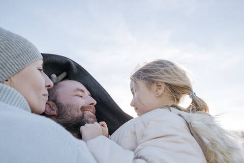 Glückliche Eltern mit kleiner Tochter im Winter, lizenzfreies Stockfoto