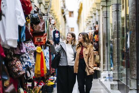 Zwei glückliche junge Frauen beim Einkaufen in der Stadt, lizenzfreies Stockfoto