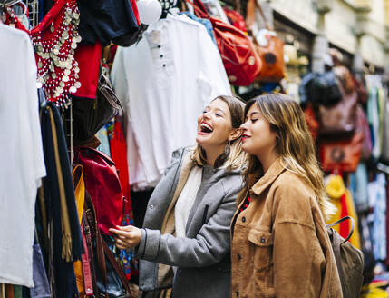 Zwei glückliche junge Frauen beim Einkaufen in der Stadt - DGOF00586