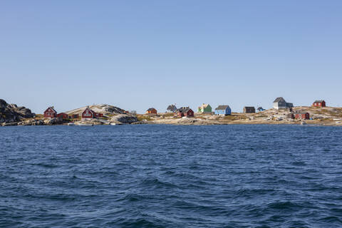 Multicolor houses on sunny remote ocean coast Disko Bay West Greenland stock photo