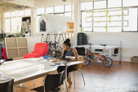 Kreative Geschäftsfrau bei der Arbeit in einem Großraumbüro, lizenzfreies Stockfoto