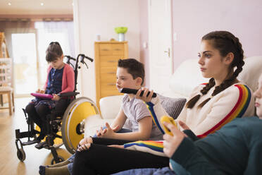 Familie mit Kind mit Down-Syndrom sieht im Wohnzimmer fern - HOXF05930