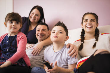 Happy family watching TV on sofa - HOXF05944