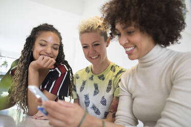 Young women friends using smart phone - HOXF06034