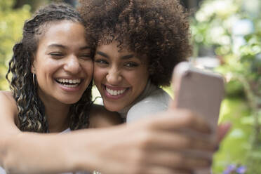 Happy playful young women friends taking selfie with camera phone - HOXF06064