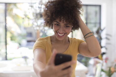 Confident smiling young woman taking selfie with camera phone - HOXF06070