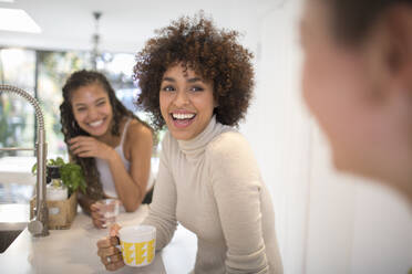 Glückliche junge Frauen, die in der Küche lachen und Tee trinken - HOXF06107