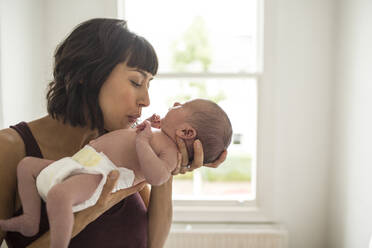 Affectionate mother holding newborn baby son - HOXF06185