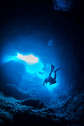 Low Angle View of Scuba Divers Schwimmen in Höhle - EYF01518