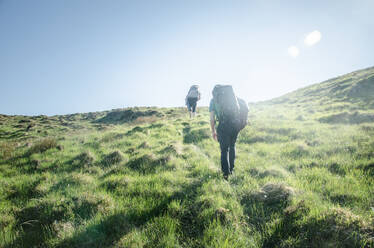 Rear View Of Man Climbing Mountain Against Sky - EYF01547