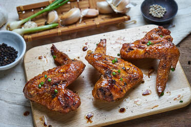 High Angle View of Fried Chicken Wings On Cutting Board Over Able - EYF01579